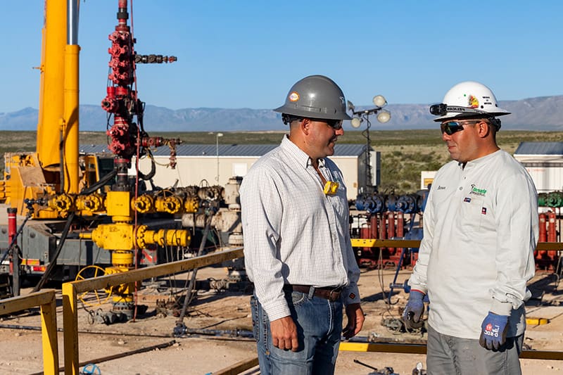 Two men talking on a well pad